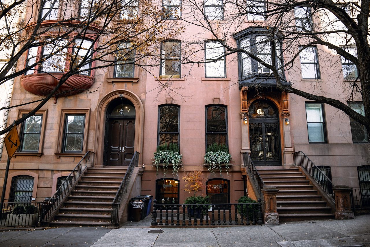 A row of brownstone houses on a Brooklyn street in autumn